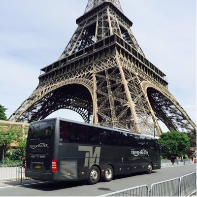 A black Travel Master coach parked in front of the Eiffel Tower